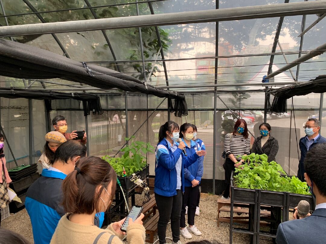 本場傅仰人副場長 (右1)參加板橋高中食育實驗室開幕活動，學生介紹校園一米菜園。
