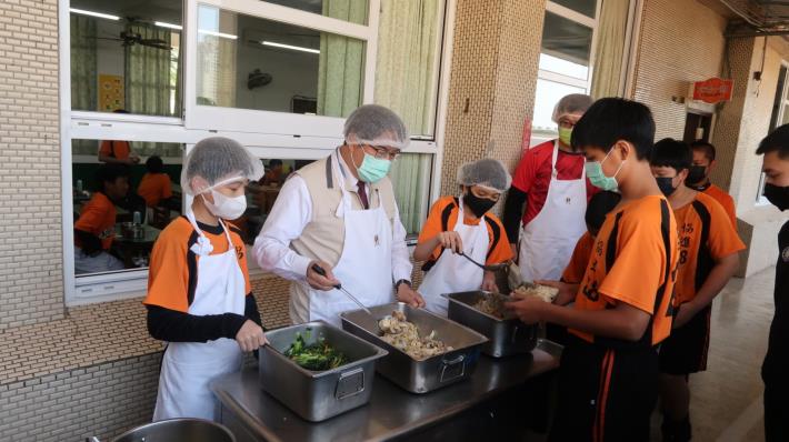黃偉哲市長視察學校營養午餐為學生打菜