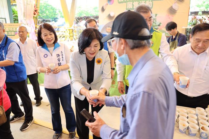 張縣長現場發送雲林當季現採的蒜頭和豬肉產品供民眾試吃品嚐